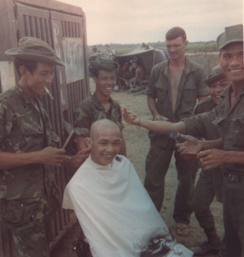 Beheler at the haircut of a Tiger scout who is thanking Budda for saving him